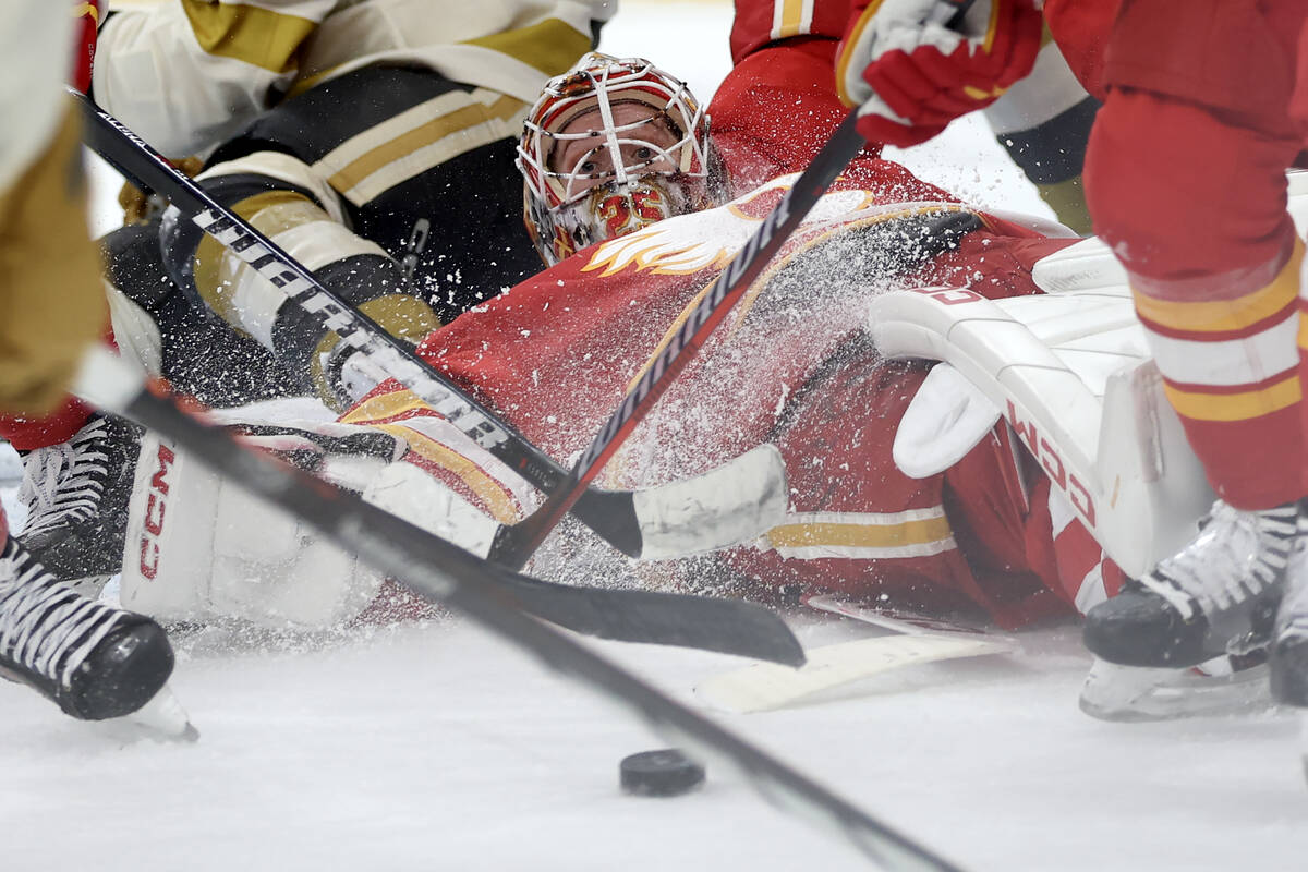 Flames goaltender Jacob Markstrom (25) watches the puck as Flames defensemen tip it out of the ...