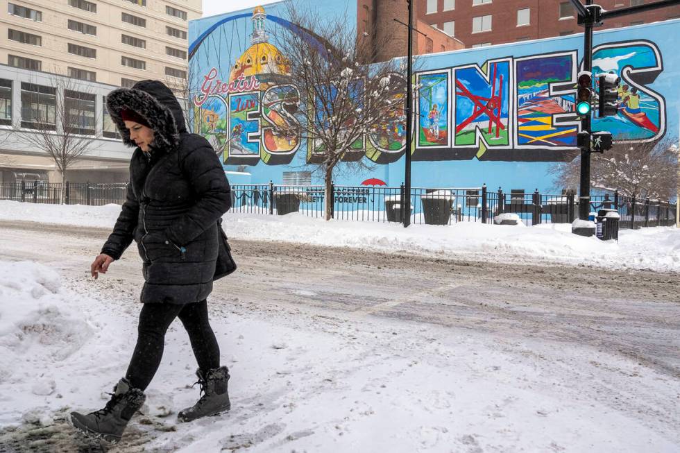 A woman walks past a mural in downtown Des Moines, Iowa, Saturday, Jan. 13, 2024. (AP Photo/And ...