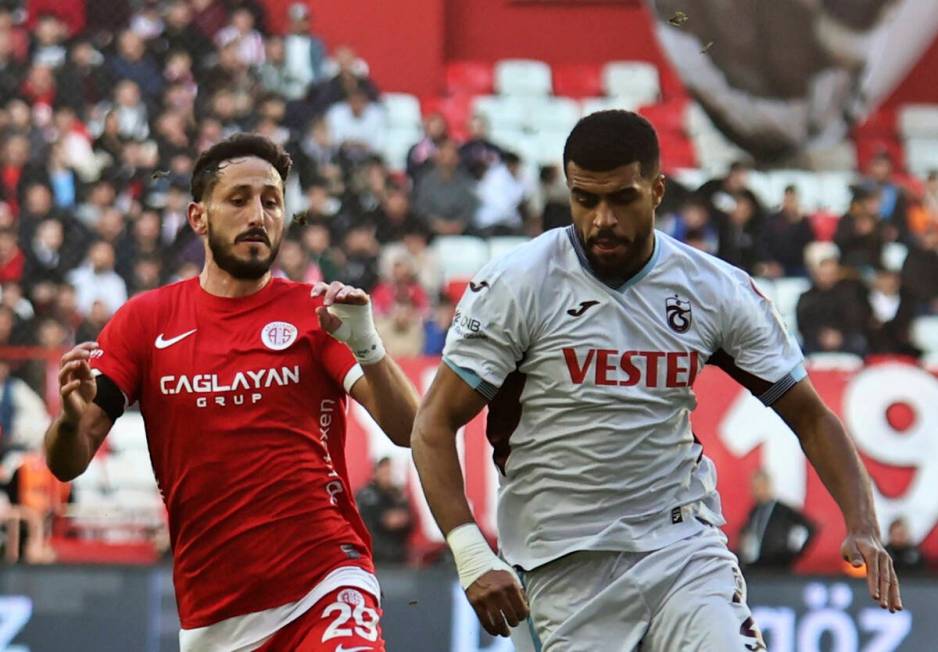 Antalyaspor's Sagiv Jehezkel, left, vies for the ball with Trabzonspor's Rayyan Baniya during a ...