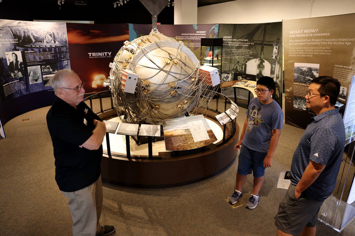 Docent David Barber, left, talks to Dennis Heng, 12, and his father Chamroeun Heng about J. Rob ...