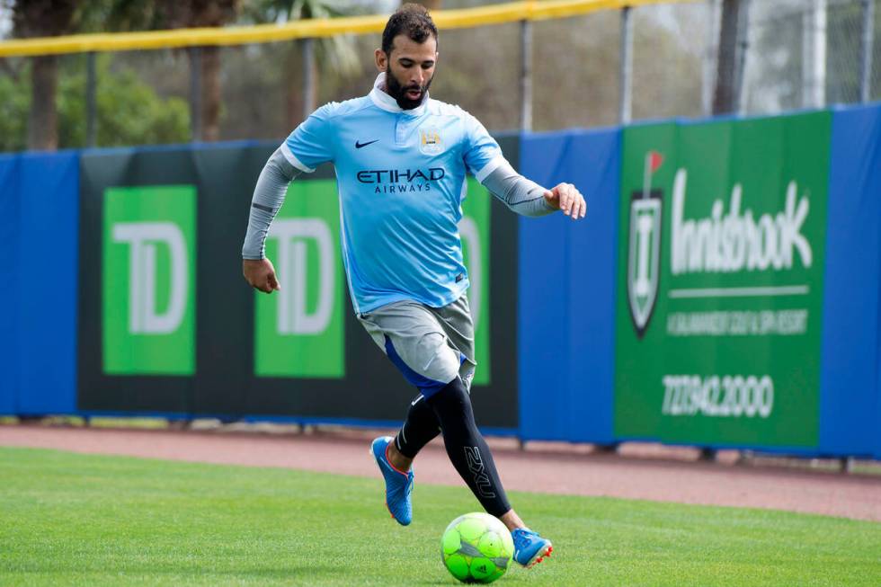FILE - Toronto Blue Jays' Jose Bautista takes to the outfield with a soccer ball after rain sho ...
