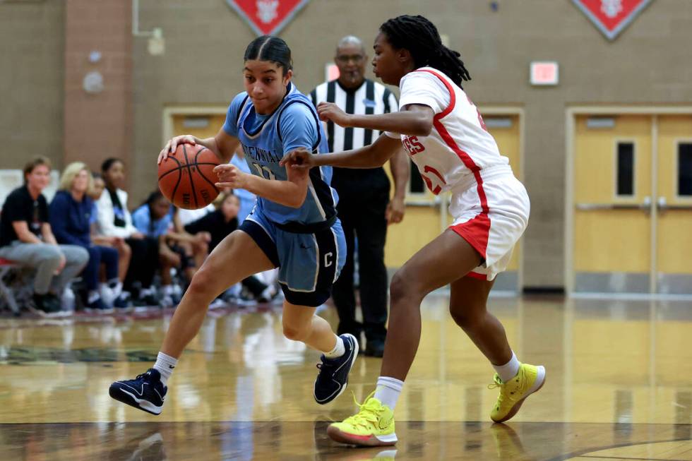 Centennial's Danae Powell (11) drives toward the hoop against Arbor View's Annesia Jackson (21) ...