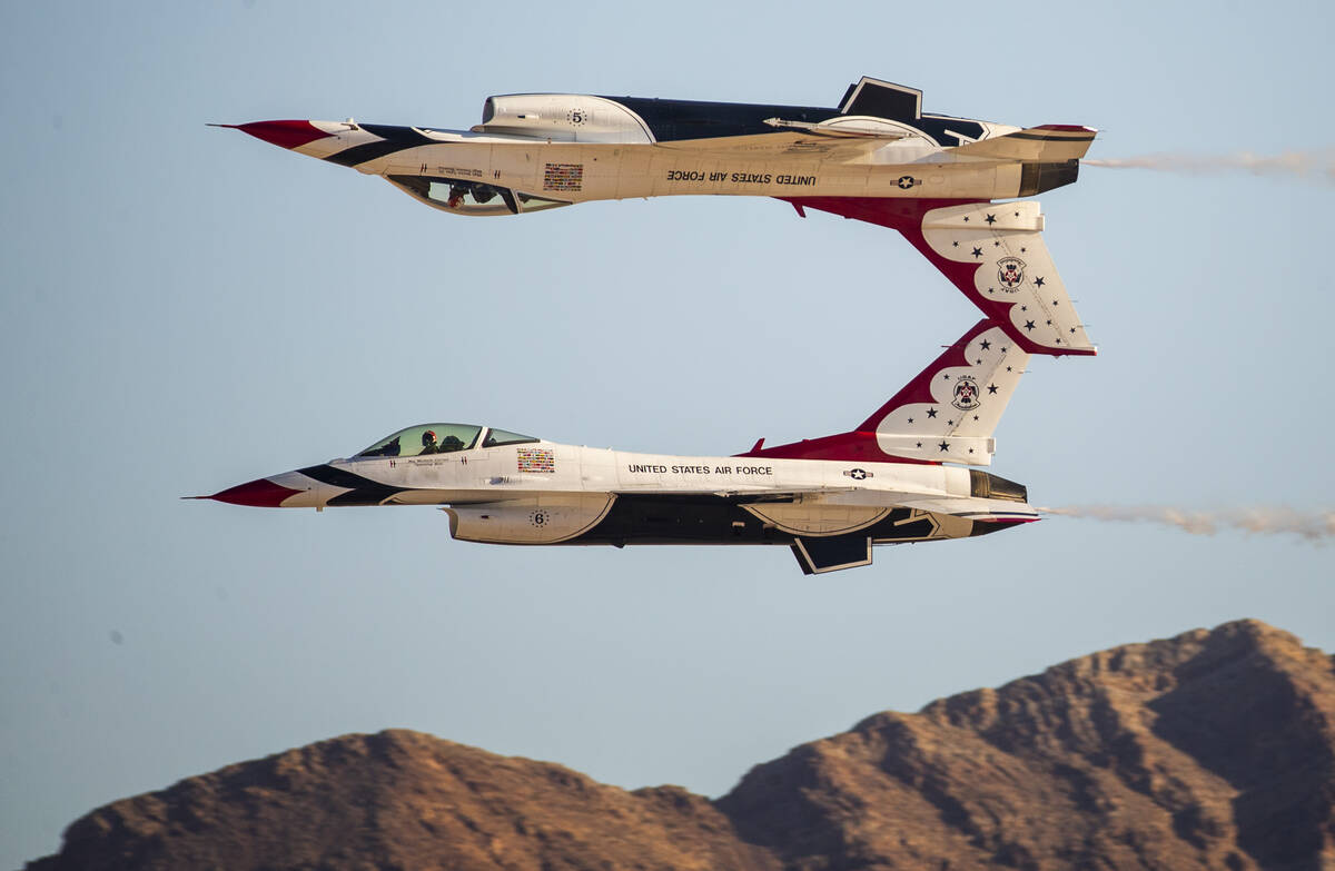 Two jets from the U.S. Air Force Thunderbirds, one of them flying inverted, perform during the ...