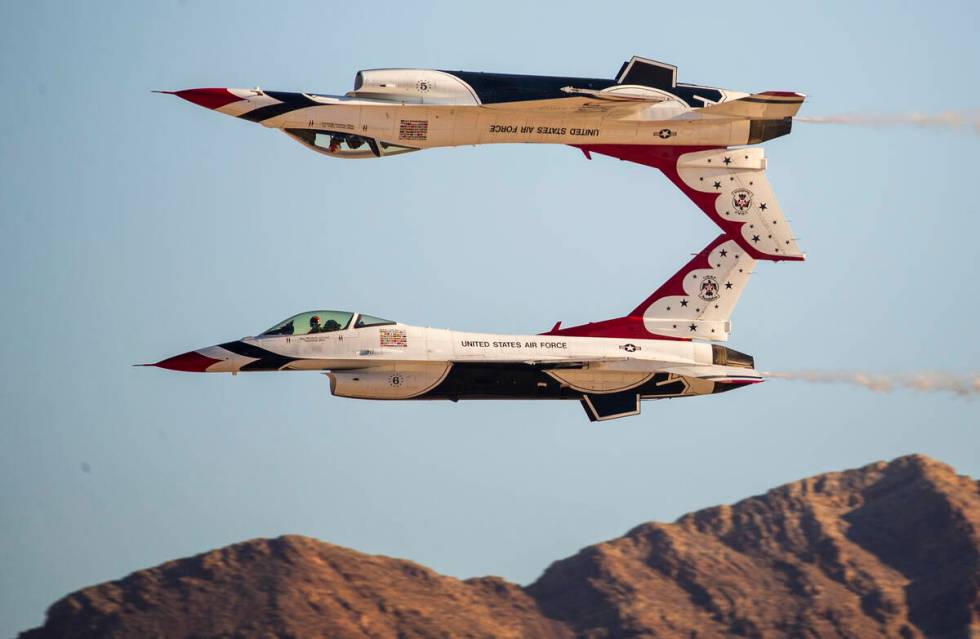 Two jets from the U.S. Air Force Thunderbirds, one of them flying inverted, perform during the ...