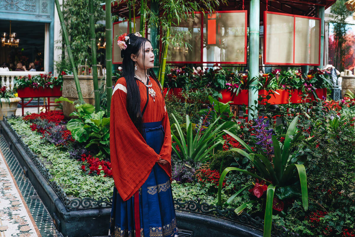 A woman in traditional Chinese clothing takes in a Chinese New Year themed display at the Bella ...