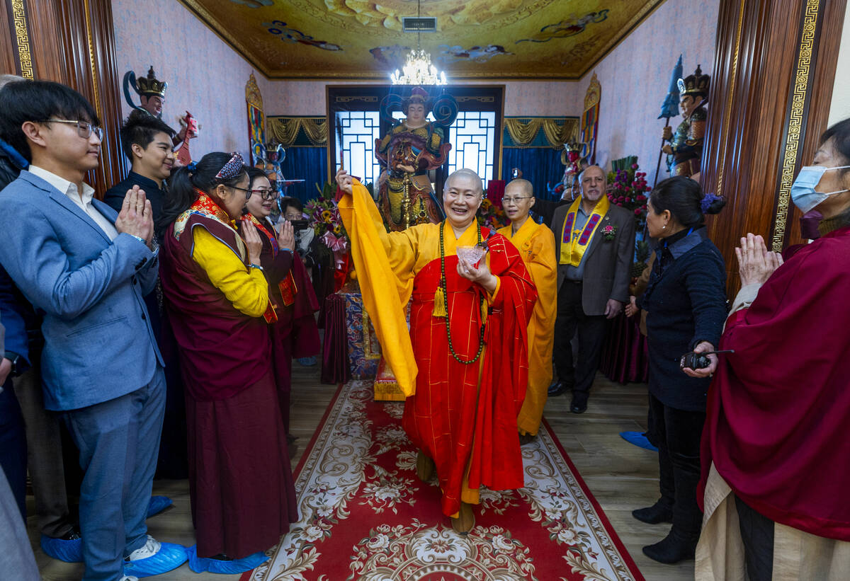 Holy Guru Zhengda Jiaozun sprinkles blessed water on attendees while joined by invited dignitar ...