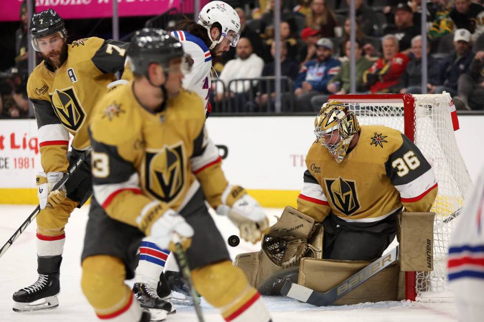 Golden Knights goaltender Logan Thompson (36) saves the puck while Rangers center Mika Zibaneja ...