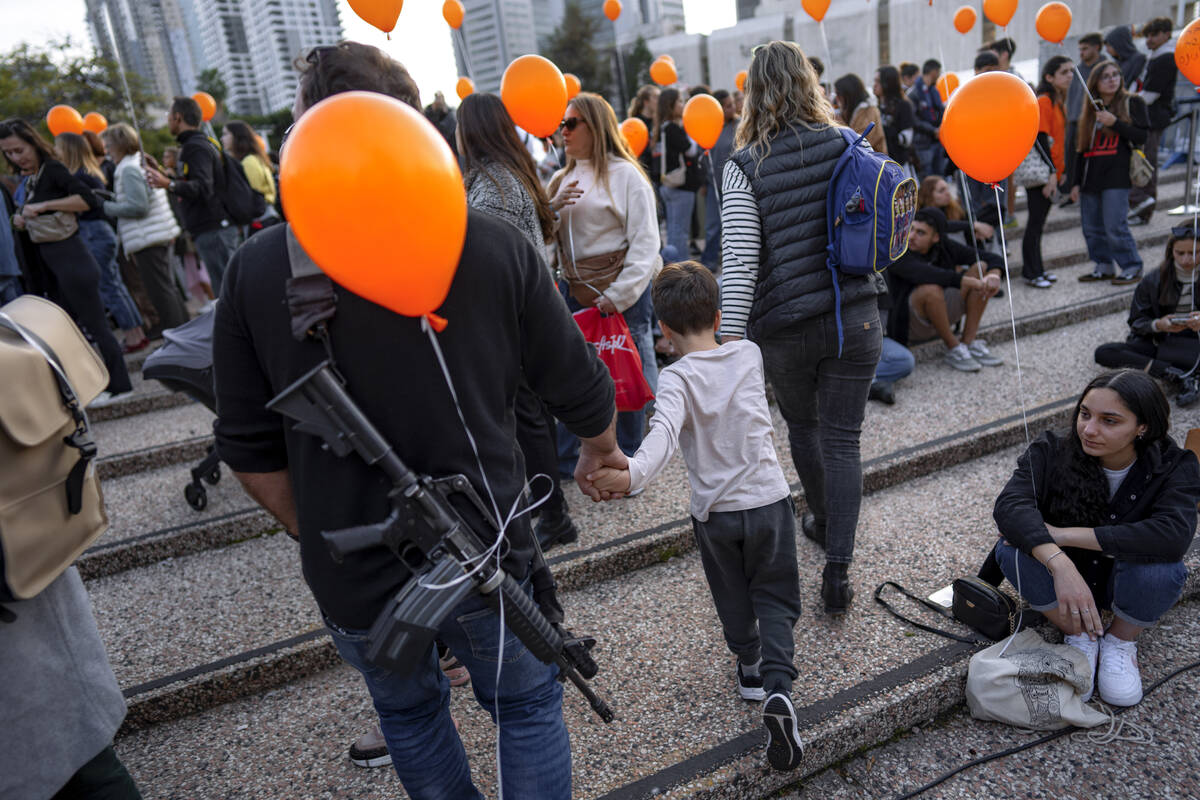 Demonstrators hold orange balloons at a rally in solidarity with Kfir Bibas, an Israeli boy who ...