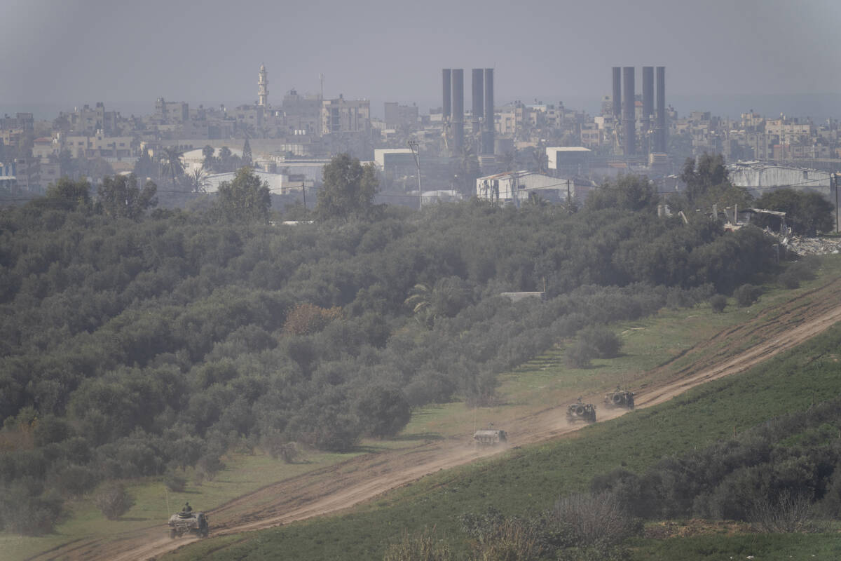 Israeli forces move near the Israeli-Gaza border, in southern Israel, Thursday, Jan. 18, 2024. ...