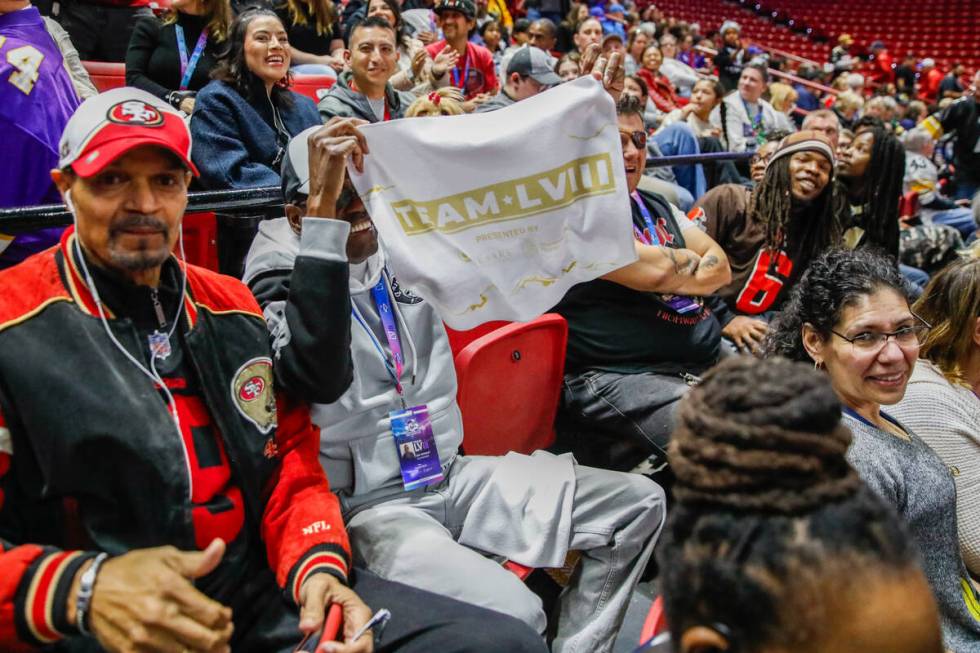 Julius Jackson, left, cheers on his fellow volunteers as Ray Stewart holds up a Super Bowl LVII ...