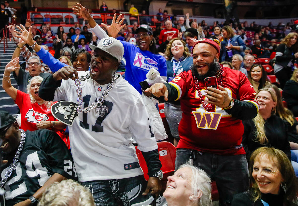 Howard Greer, left, and Brian Baldwin, both volunteers for Super Bowl LVIII, hype up their fell ...