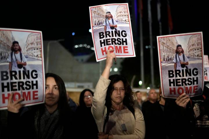 People hold signs showing a picture of a hostage during a demonstration calling for the release ...