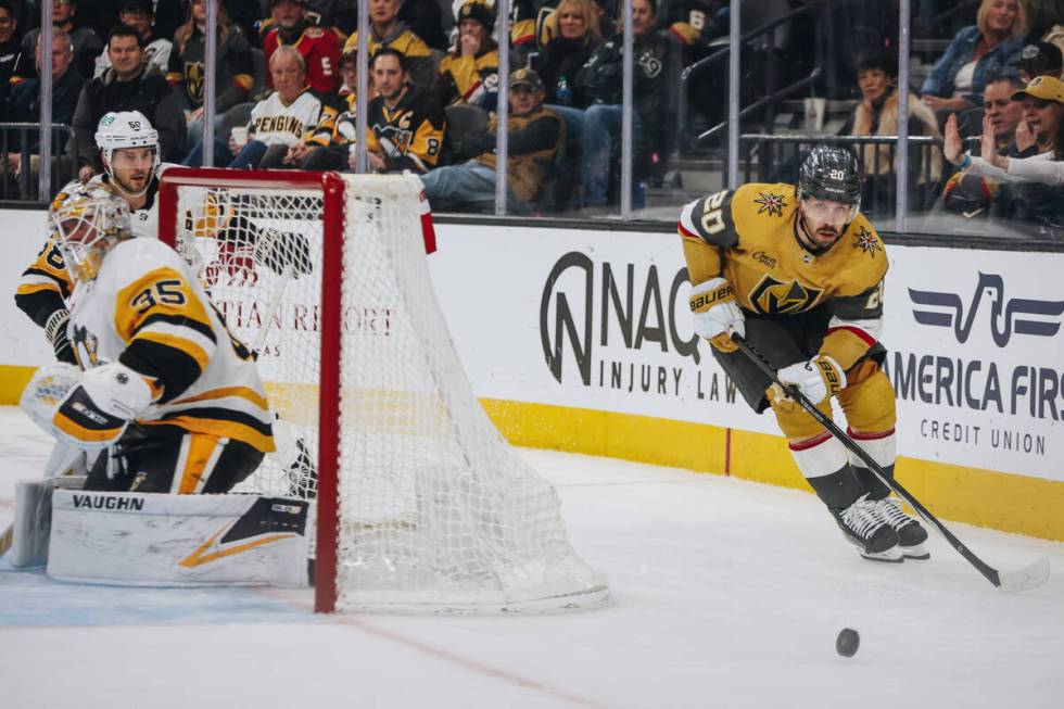 Golden Knights center Chandler Stephenson (20) shuffles the puck behind the net during a game a ...