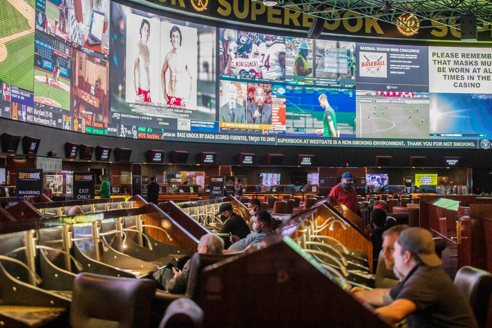 Guests watch the screens at the Westgate sportsbook in Las Vegas, Wednesday, March 3, 2021. (Ra ...