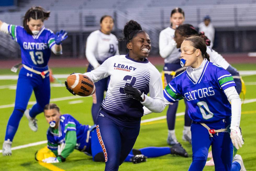 Green Valley’s Kaylee Montalvo (0) pulls the flag off of Legacy’s Mailaya Taylor ...