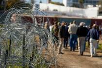 FILE - Concertina wire lines the path as members of Congress tour an area near the Texas-Mexico ...