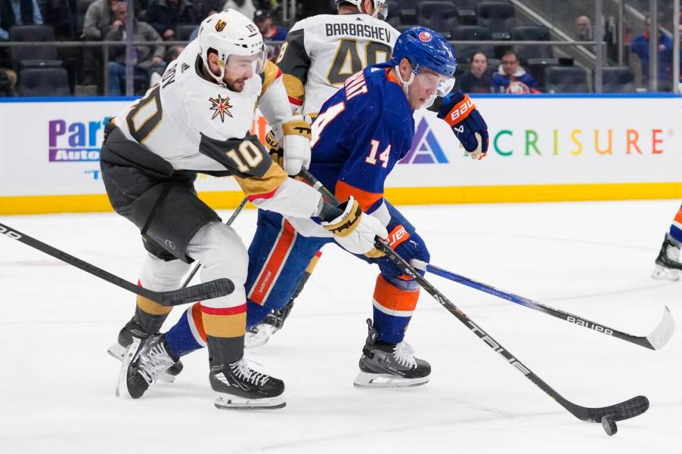 Vegas Golden Knights' Nicolas Roy (10) fights for control of the puck with New York Islanders' ...