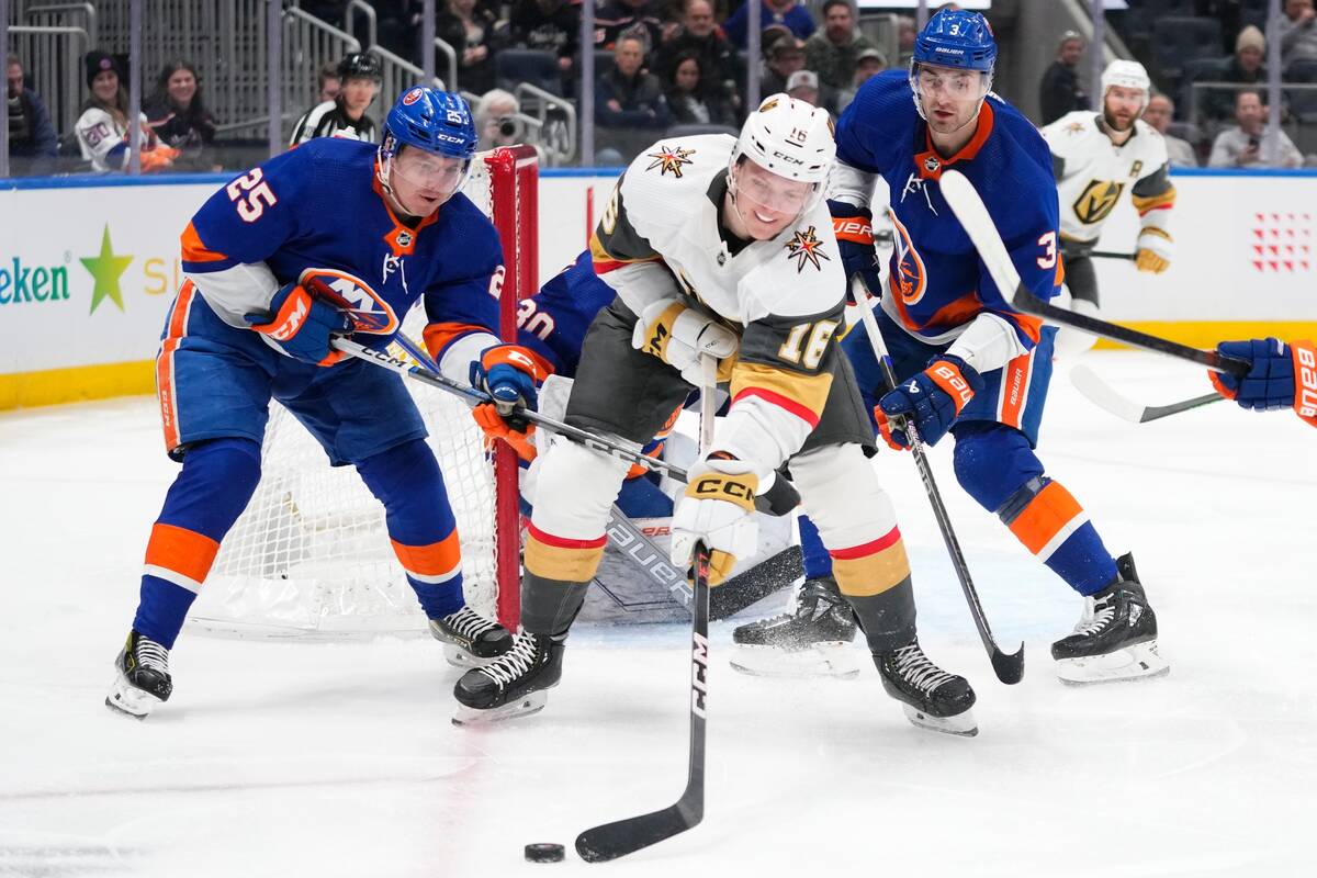 Vegas Golden Knights' Pavel Dorofeyev (16) fights for control of the puck with New York Islande ...