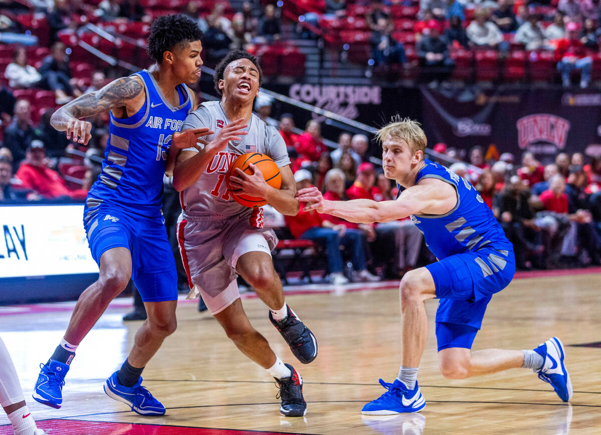 UNLV guard Dedan Thomas Jr. (11) drives past Air Force Falcons forward Chase Beasley (13) while ...