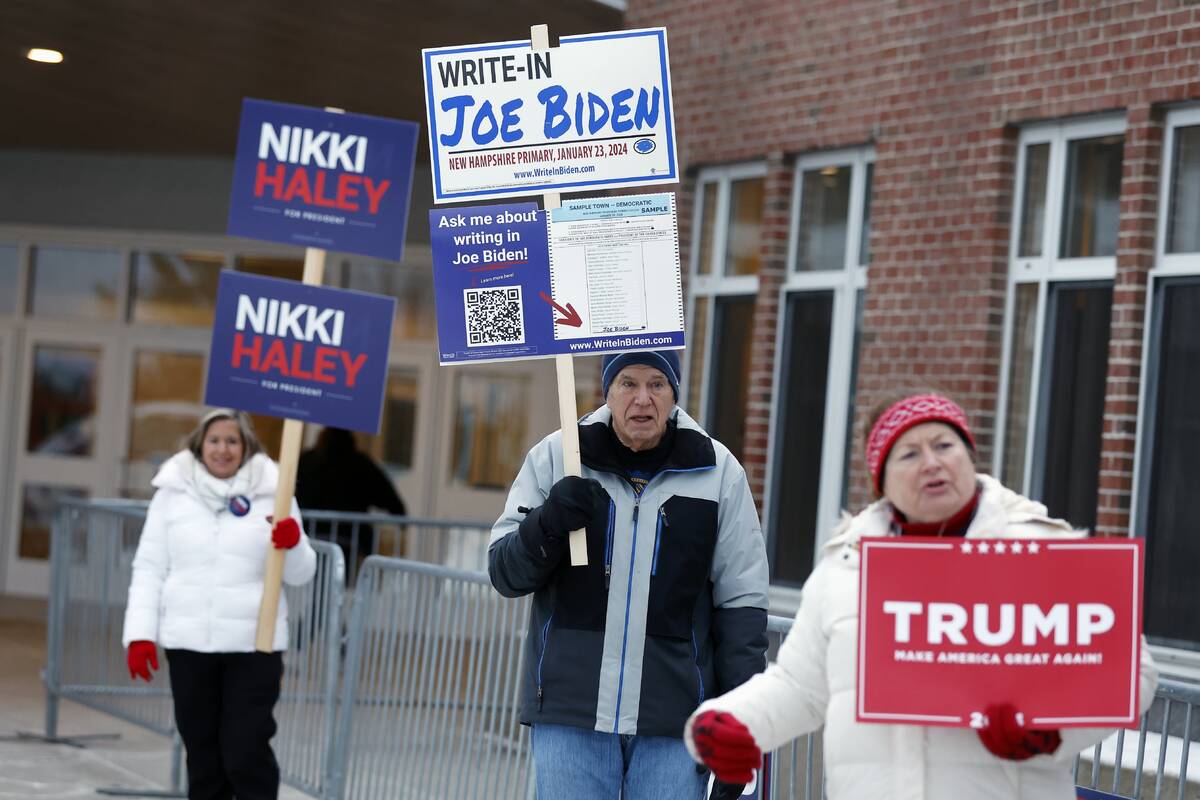 Candidate supporters stand outside the Windham High School polling place in the presidential pr ...