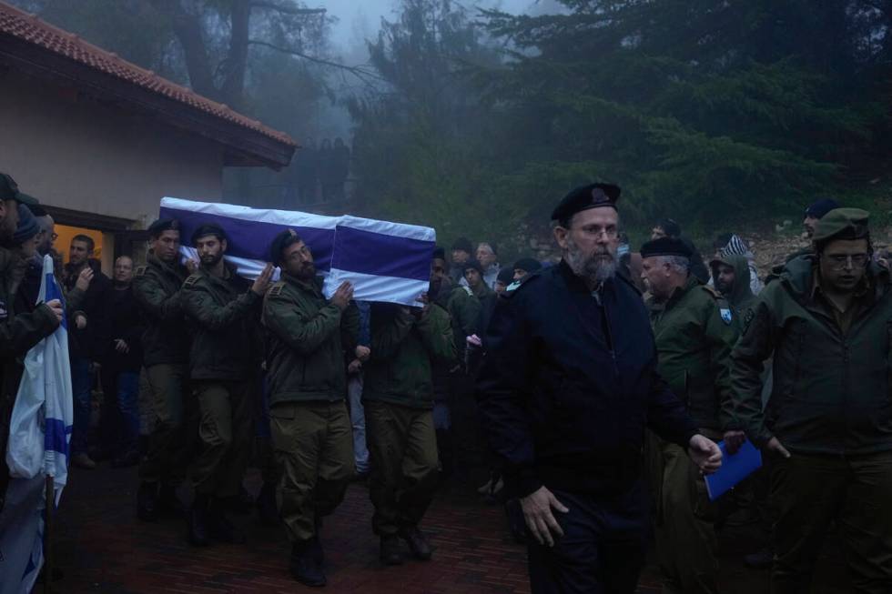 Israeli soldiers carry the flag-draped casket of reservist Ariel Mordechay Wollfstal during his ...