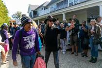 A Venezuelan migrant is led onto a bus at St. Andrews Episcopal Church on Friday, Sept. 16, 202 ...