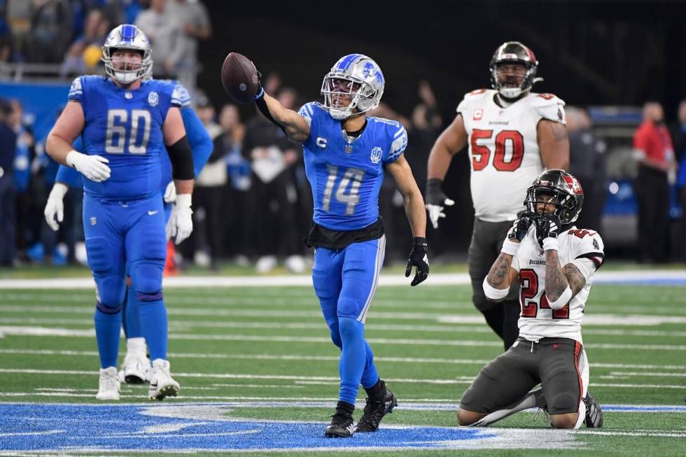 Detroit Lions' Amon-Ra St. Brown (14) reacts after catching a pass for a first down in front of ...