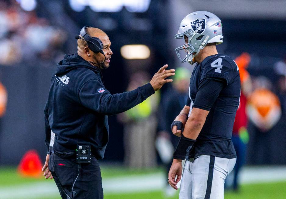 Raiders interim head coach Antonio Pierce chats with quarterback Aidan O'Connell (4) on a timeo ...