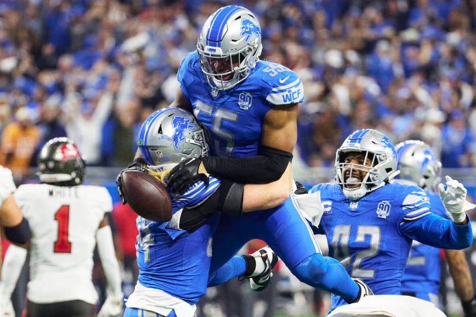 Detroit Lions linebacker Derrick Barnes (55) receives congratulations from teammates after he m ...