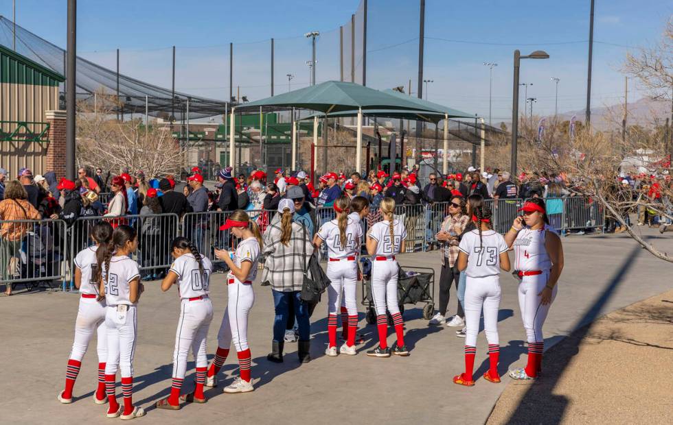 Softball players look on as supporters line up inside to see Republican presidential candidate ...