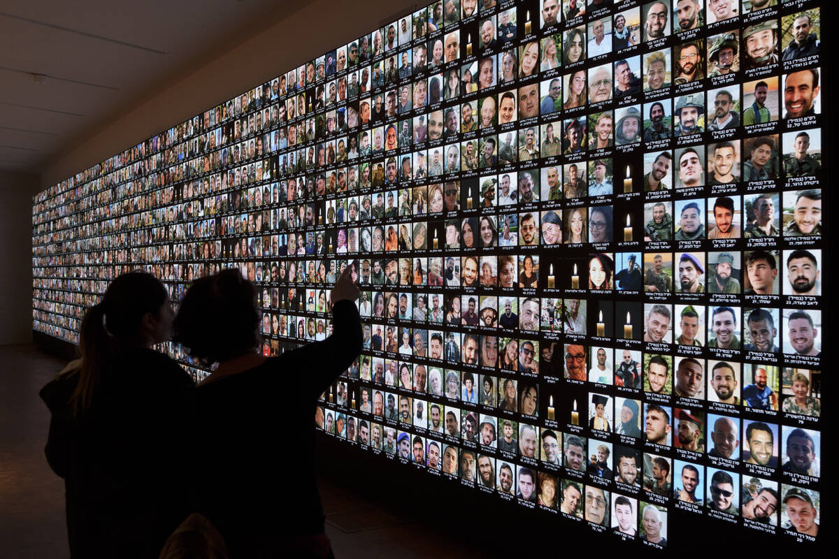 Visitors look at photos of Israeli people who were killed during Hamas militants attack on Oct. ...