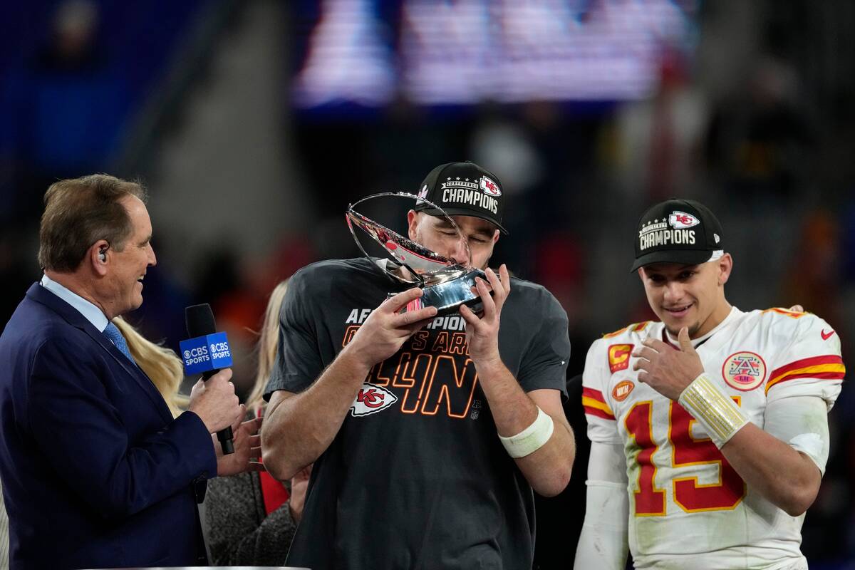 Kansas City Chiefs tight end Travis Kelce kisses the Lamar Hunt trophey after an AFC Championsh ...