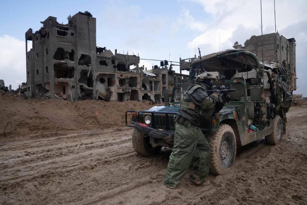 An Israeli soldier stands guard during the ground offensive on the Gaza Strip in Khan Younis, S ...