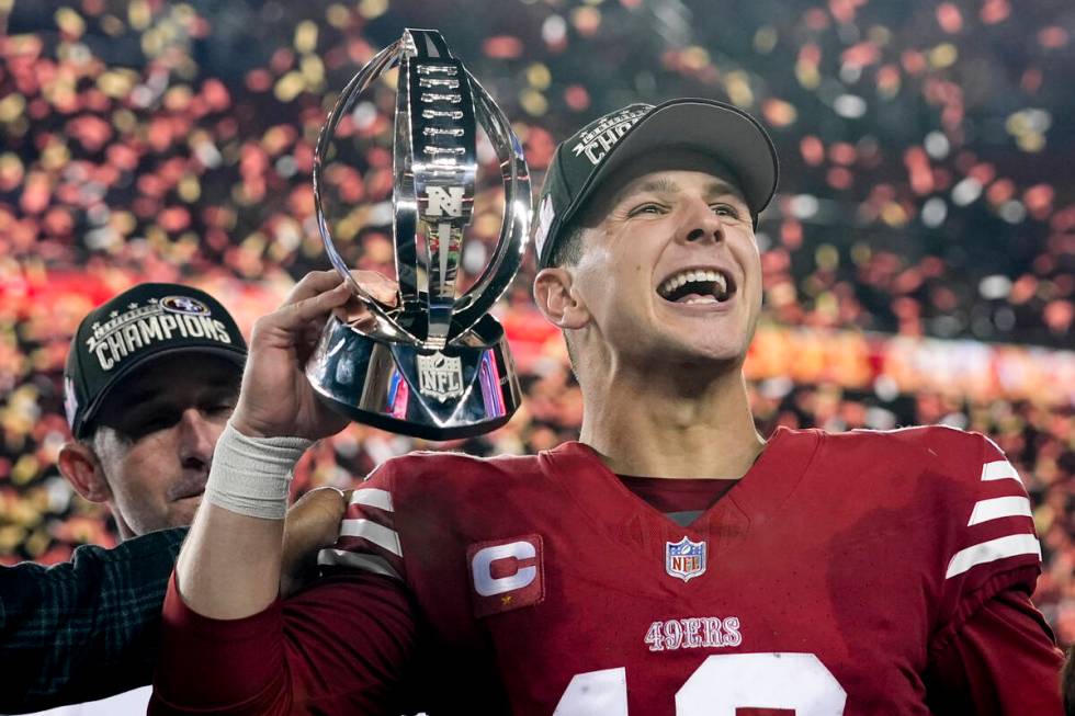 San Francisco 49ers quarterback Brock Purdy celebrates with the trophy after their win against ...