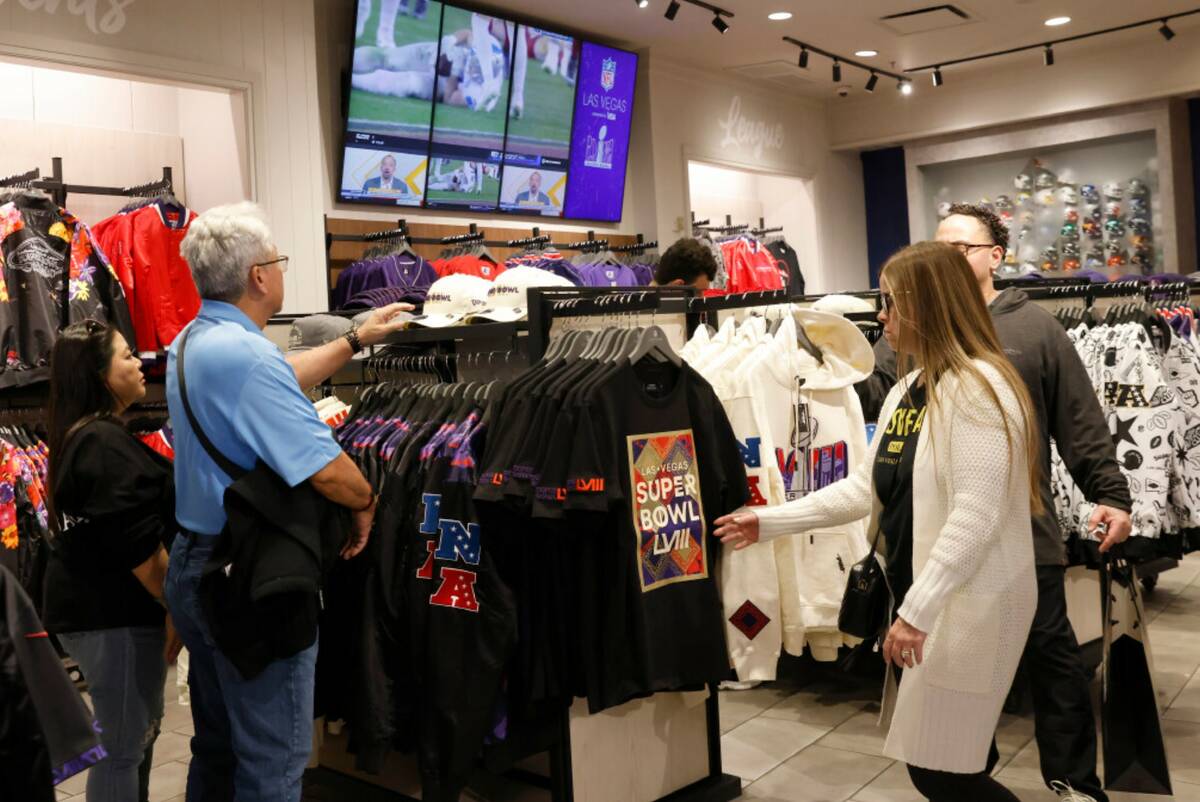 Shoppers check out Super Bowl LVIII merchandise at the NFL Las Vegas store at the Forum Shop, o ...