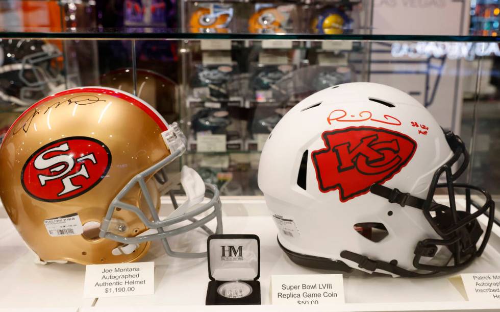 Authentic Helmets signed by Joe Montana, left, and Patrick Mahomes are displayed at the NFL Las ...