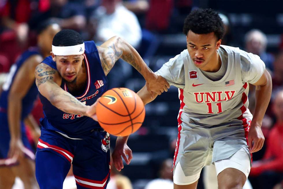 UNLV Rebels guard Dedan Thomas Jr. (11) and Fresno State Bulldogs guard Isaiah Hill (3) rush fo ...