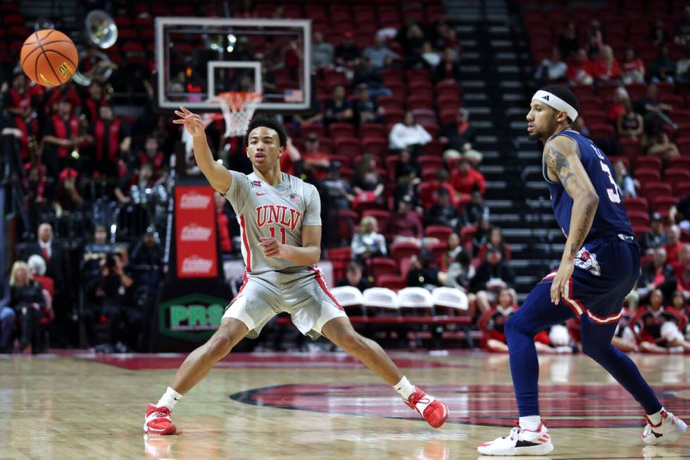 UNLV Rebels guard Dedan Thomas Jr. (11) passes while Fresno State Bulldogs guard Isaiah Hill (3 ...