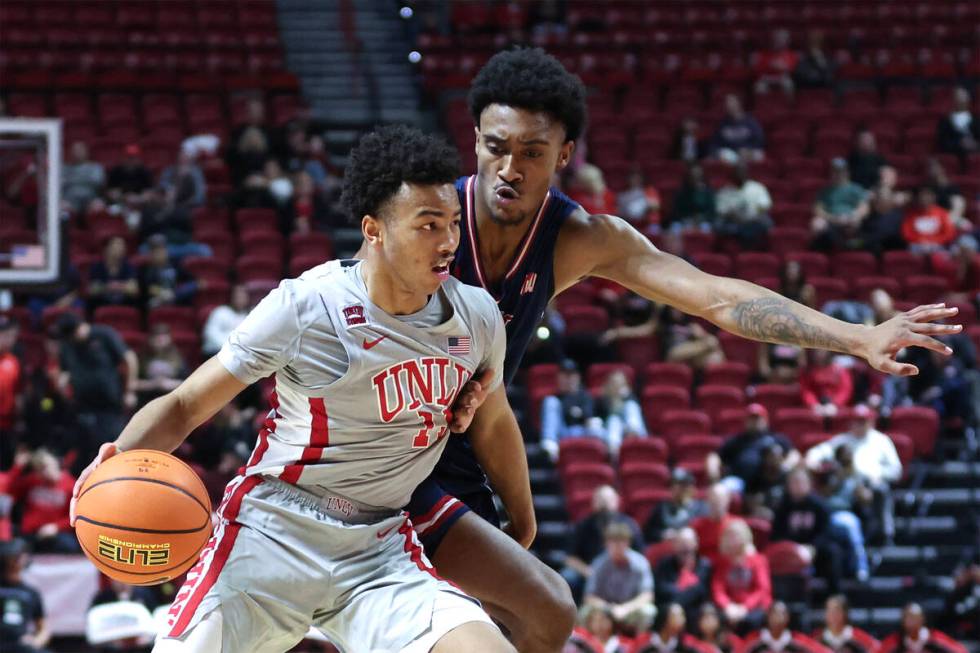 UNLV Rebels guard Dedan Thomas Jr. (11) drives around Fresno State Bulldogs guard Leo Colimerio ...