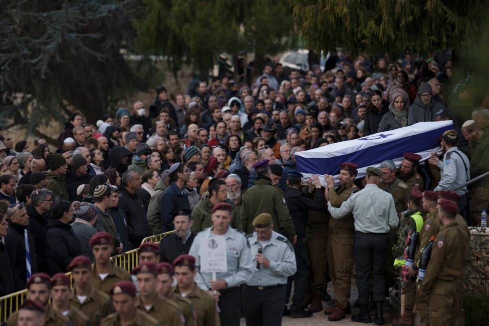 Israeli soldiers carry the flag-draped casket of reservist warrant officer Yuval Nir during his ...