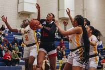 Liberty’s Daisha Peavy (12) fights to move the ball past Democracy Prep defenders during ...