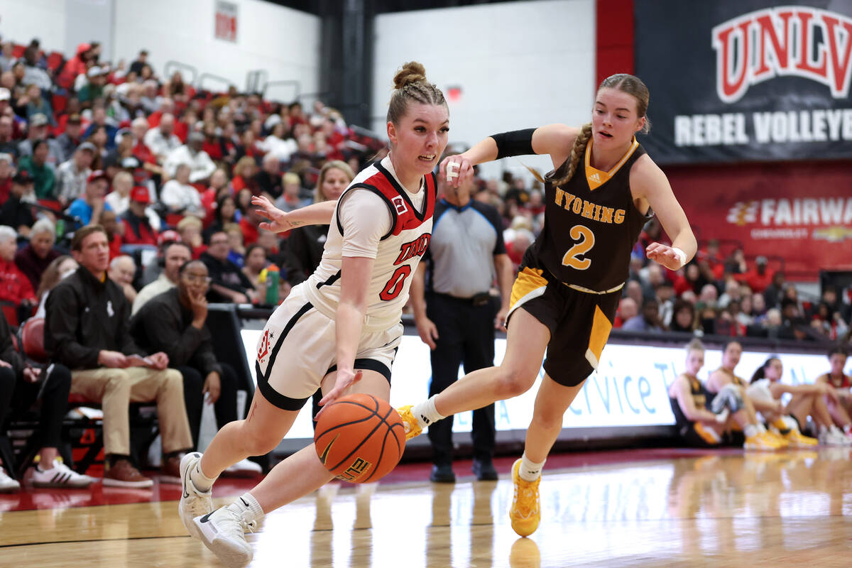 UNLV Lady Rebels guard Ashley Scoggin (0) dribbles around Wyoming Cowgirls guard Emily Mellema ...