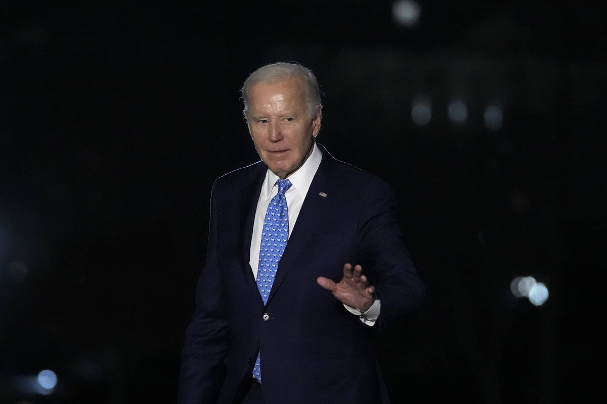 President Joe Biden waves as he walks across the South Lawn of the White House in Washington, T ...