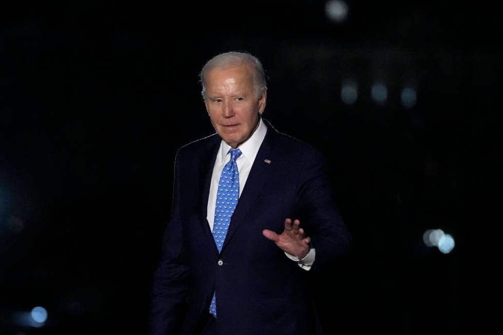 President Joe Biden waves as he walks across the South Lawn of the White House in Washington, T ...