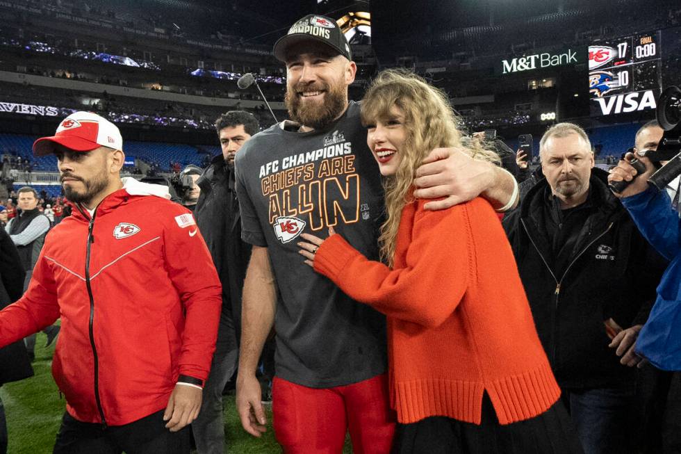 FILE - Kansas City Chiefs tight end Travis Kelce walks with Taylor Swift following the AFC Cham ...