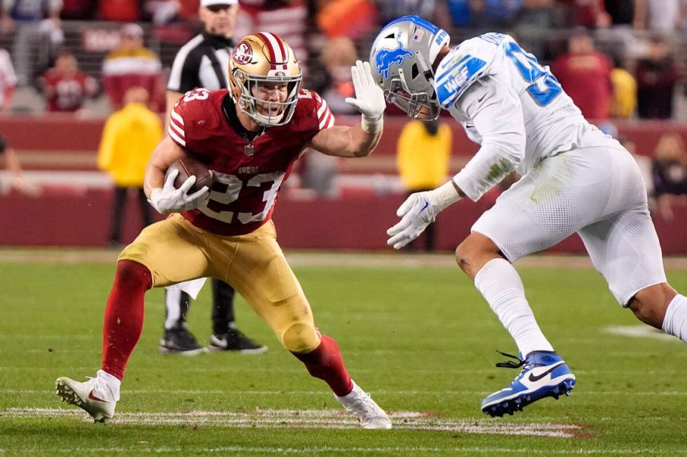 San Francisco 49ers running back Christian McCaffrey, left, fends off San Francisco 49ers defen ...