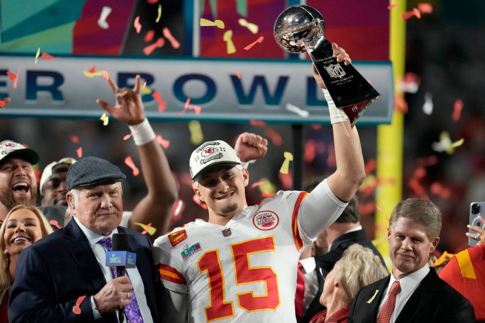 Kansas City Chiefs quarterback Patrick Mahomes (15) holds the Vince Lombardi Trophy next to Ter ...