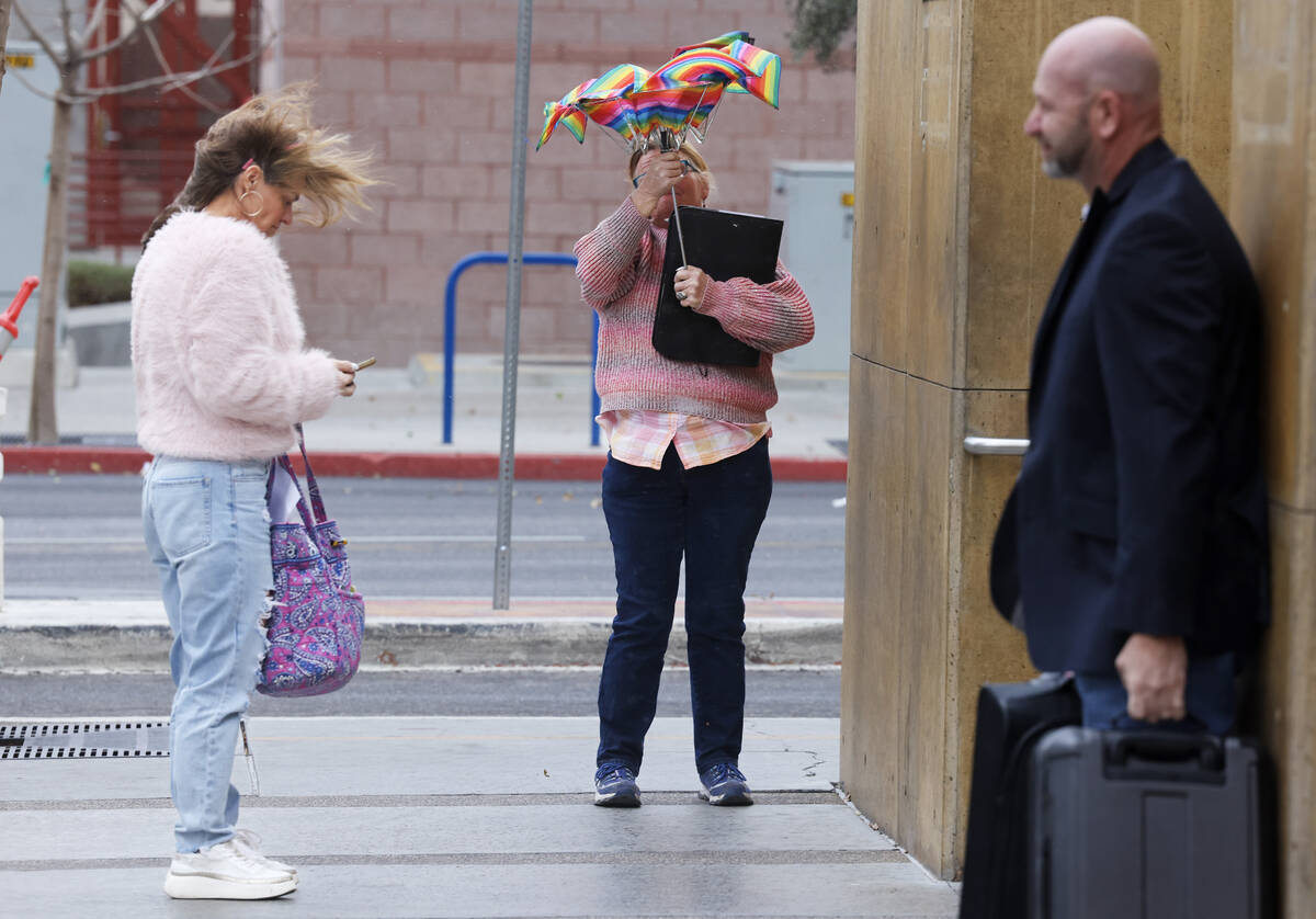 People deal with the wind and rain in downtown Las Vegas on Wednesday, Jan. 31, 2024. (K.M. Can ...
