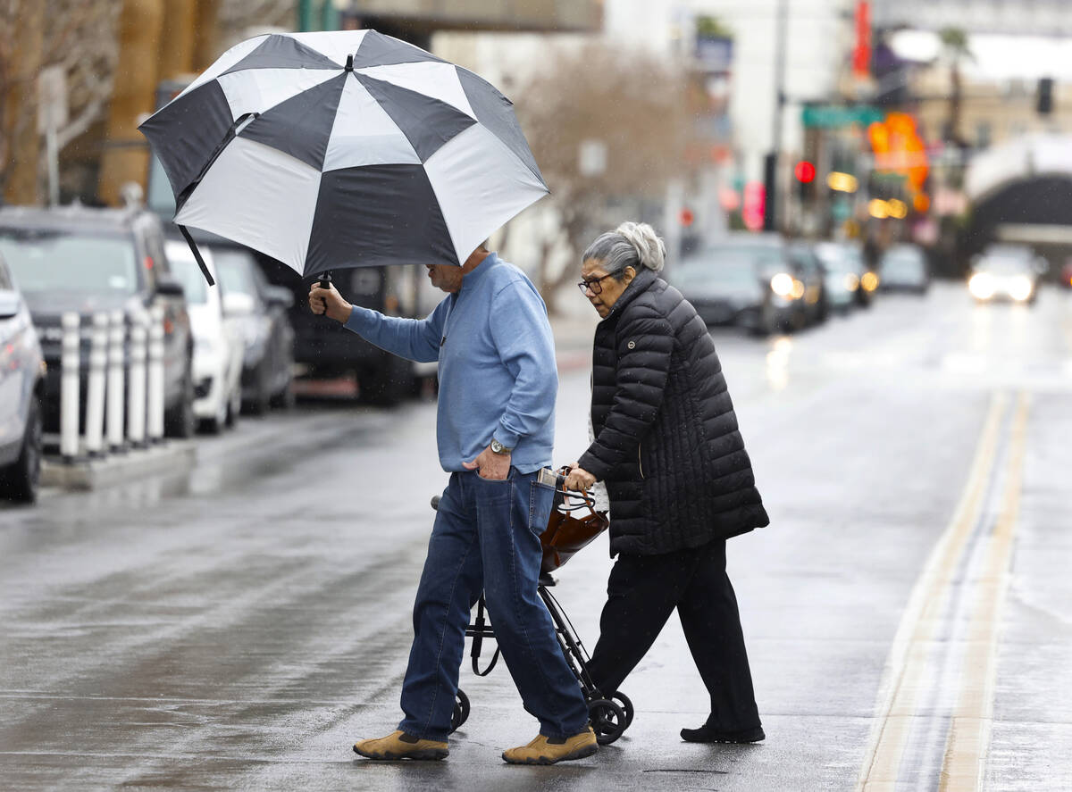 Pedestrians cross Third Street during a rainy morning, on Thursday, Feb. 1, 2024, in Las Vegas. ...