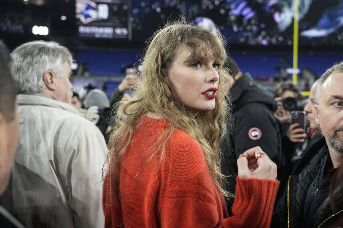 Taylor Swift speaks with people on the field after an AFC Championship NFL football game betwee ...